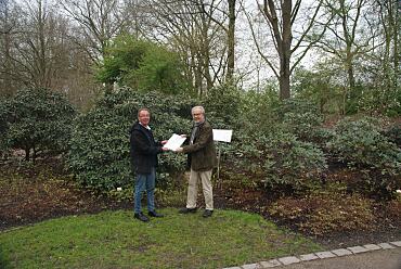 Beiratssprecher Ralf Draeger (links) und Vereinsvorsitzender Michael Koppel (rechts) mit Urkunde vor dem Beet